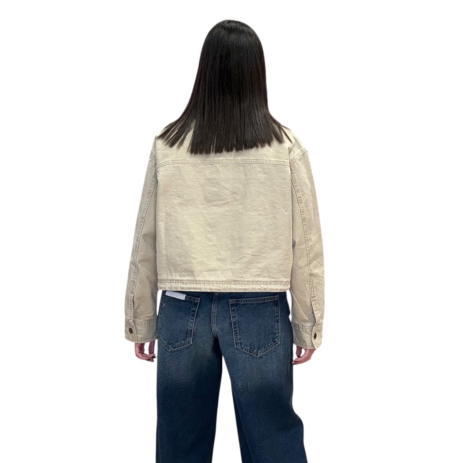 Person wearing a beige jacket and blue jeans on a white background