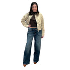 Woman wearing a beige jacket and blue jeans on a white background