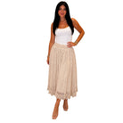 Woman wearing a beige lace skirt and white top on a white background