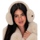 A woman wearing fluffy cream faux-fur earmuffs and a matching cream coat, shown against a plain white background.