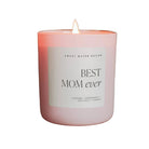 Pink candle labeled 'Best Mom Ever' on a stone block with a blurred floral background