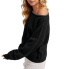 Black sweater worn by a person on a white background