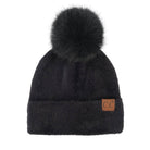 A black faux fur beanie hat featuring a large matching pom-pom on top and a small brown leather 'C.C' logo patch on the front cuff, set against a plain white background.