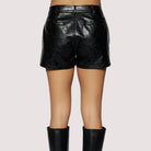 Person wearing black leather shorts and knee-high boots on a white background