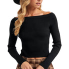 Woman wearing a black off-shoulder sweater with a blurred background
