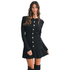 Black dress with button details worn by a model on a white background