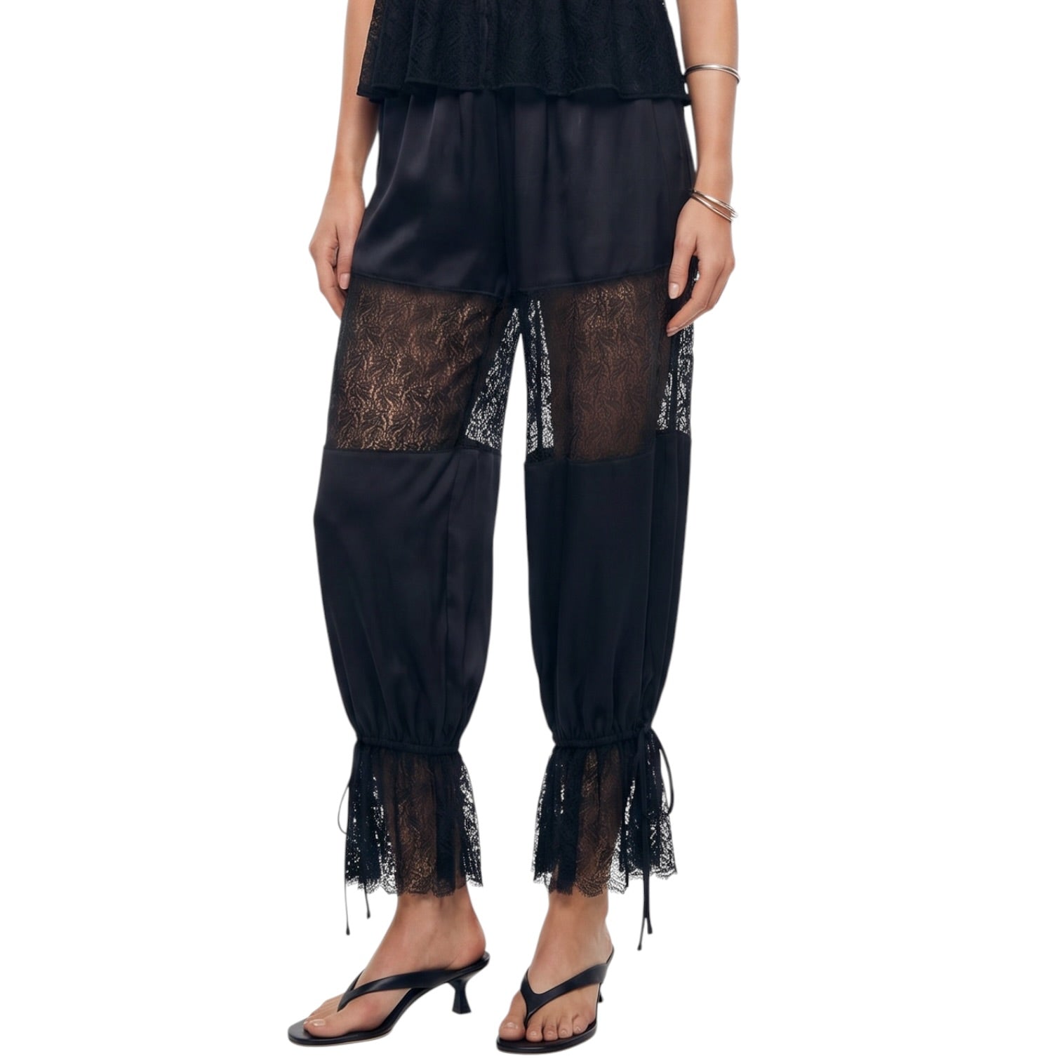 Black lace pants worn by a person on a white background