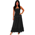 Woman wearing a black strapless dress with ruffles on a white background