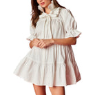 White dress with ruffled details on a white background