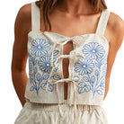 Beige shorts with blue floral patterns worn by a person on a white background