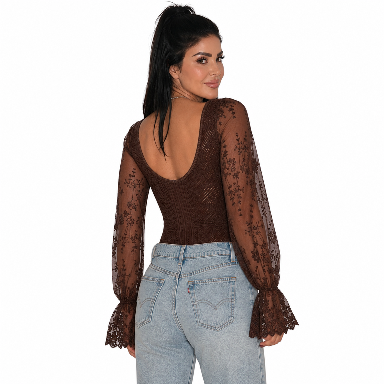 A woman shown from the back wearing a brown lace long-sleeve top with a deep open back and light-wash blue jeans, against a plain white background.