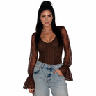 A woman modeling a brown lace long-sleeve top with a textured bodice and flared lace sleeves, paired with light-wash blue jeans, against a plain white background.