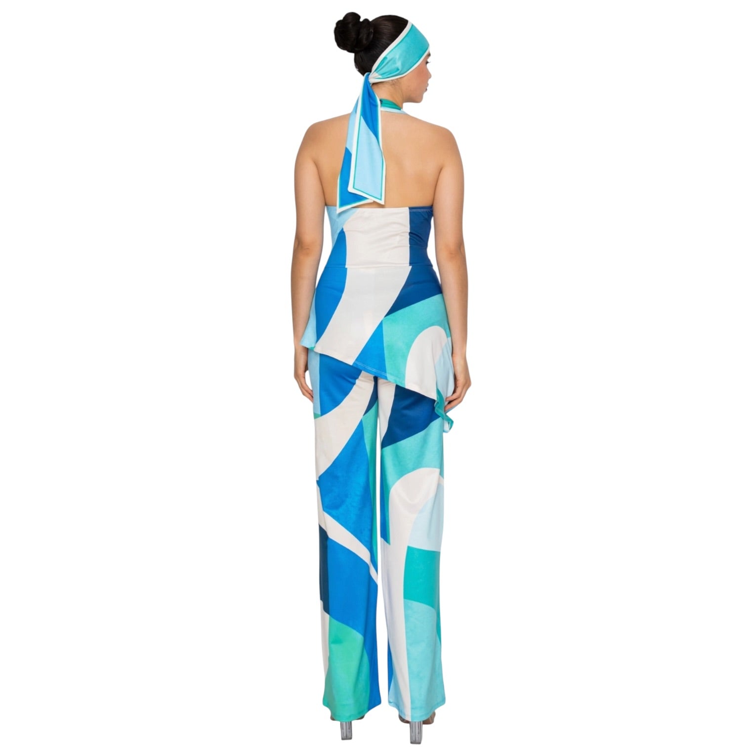 Woman wearing a blue and white patterned jumpsuit with a matching headscarf on a white background