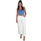 Woman wearing a blue top with white pants on a white background
