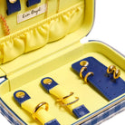 Yellow jewelry case with blue interior holding gold rings, branded 'Lisa Angel'.