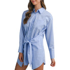 Woman wearing a blue and white striped shirt dress on a white background