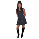 Woman wearing a plaid dress and black boots on a white background