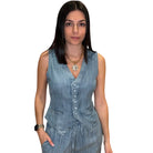 Woman wearing a denim vest and pants on a white background
