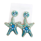 Starfish-shaped earrings with turquoise and blue bead details on a white background