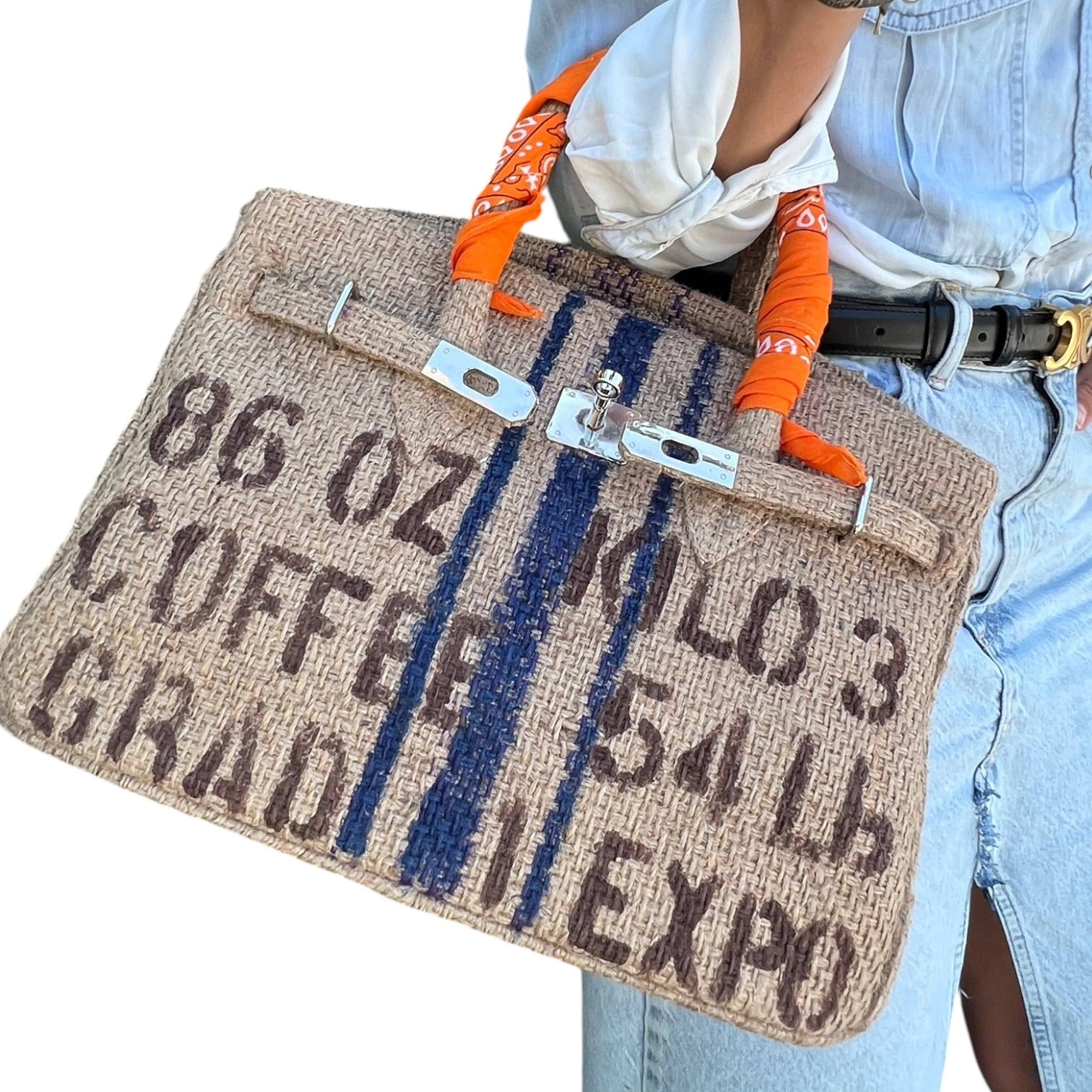 Person holding a textured bag with text and orange handles