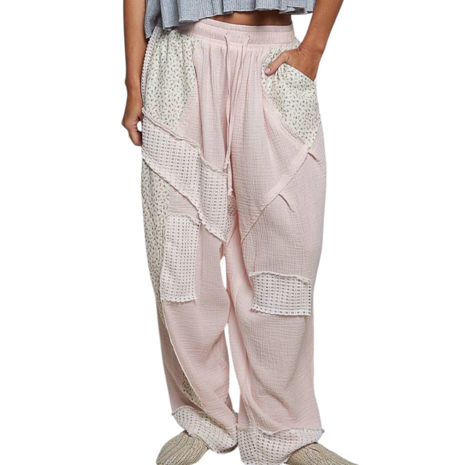 Light pink pants with lace detailing worn by a person on a white background