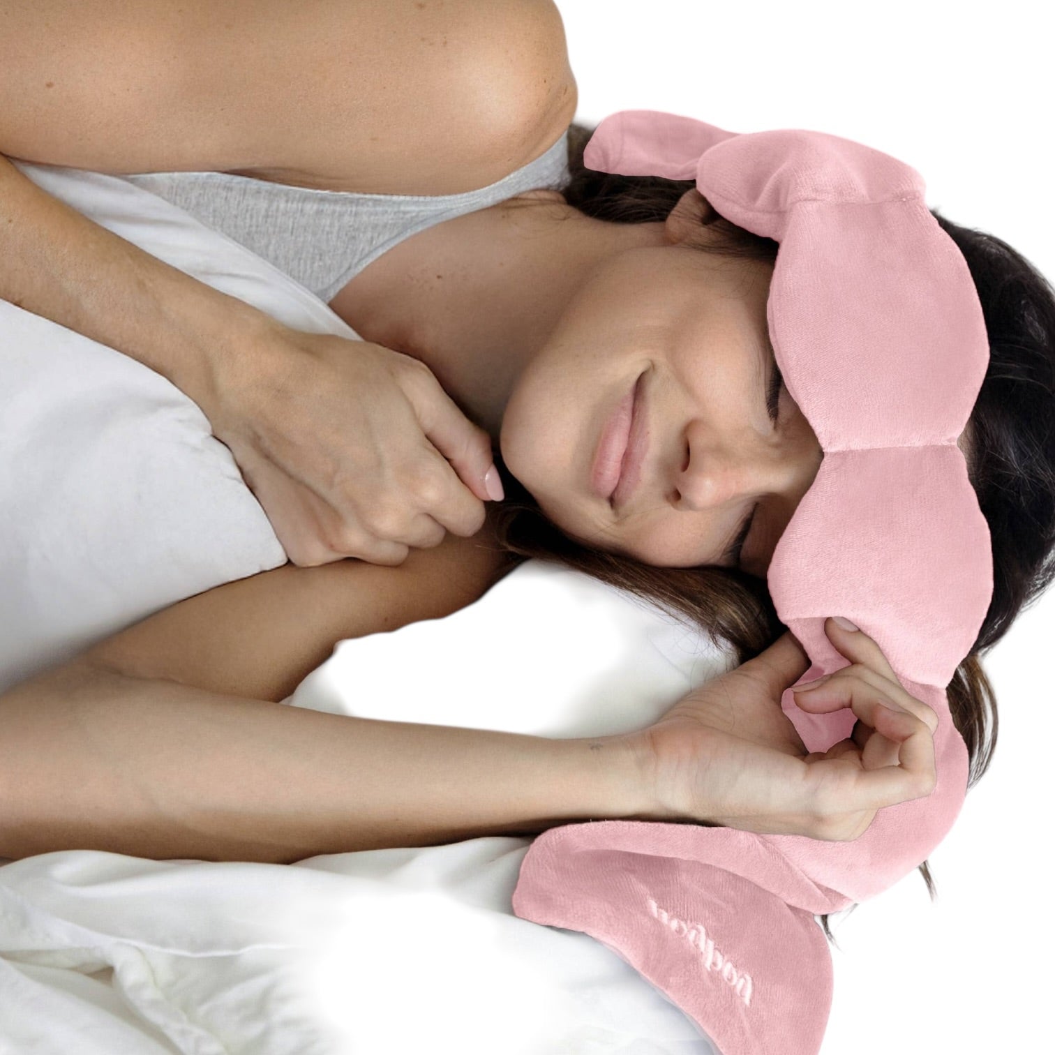 Person lying down with a pink eyemask and white blanket