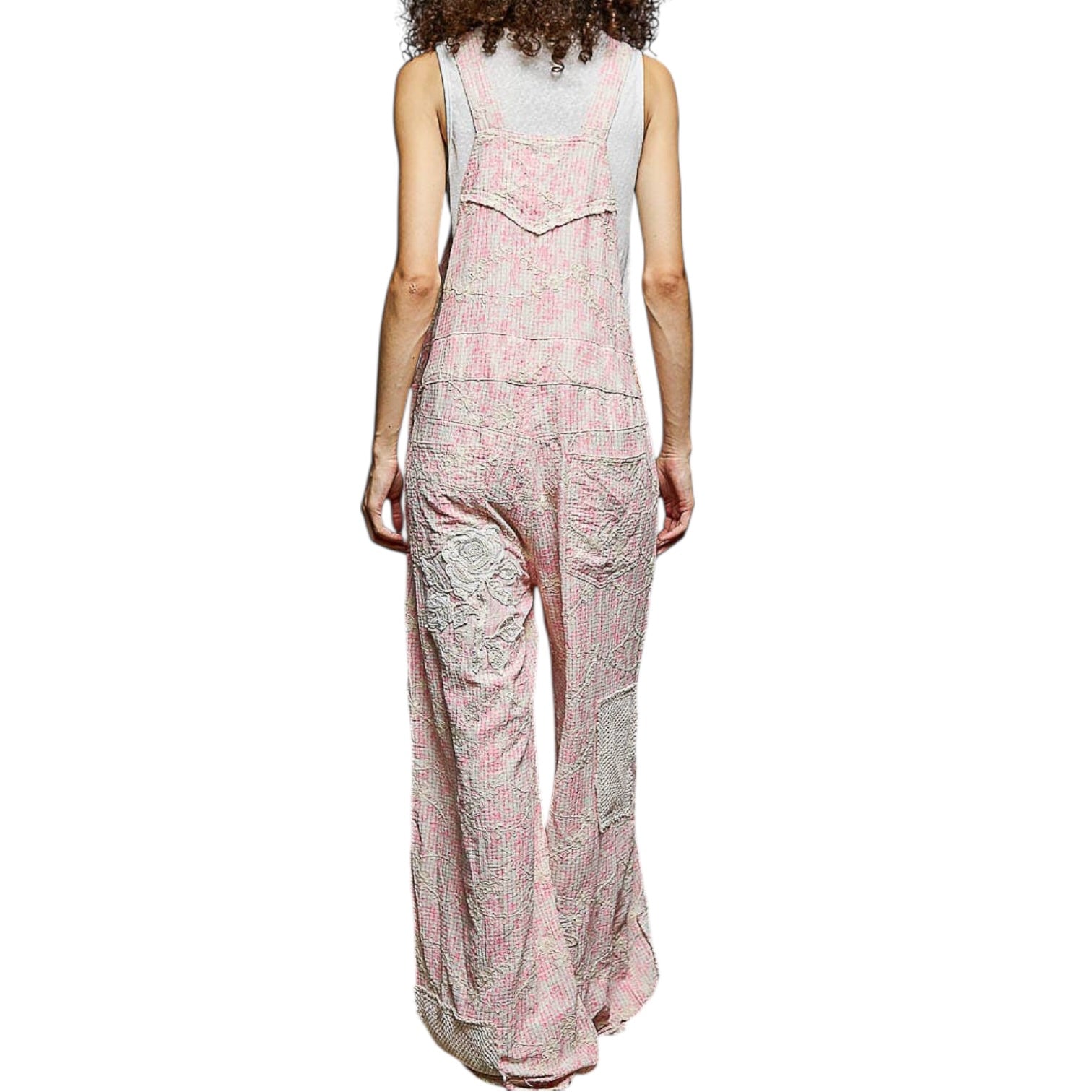 Person wearing a pink and white patterned jumpsuit on a white background