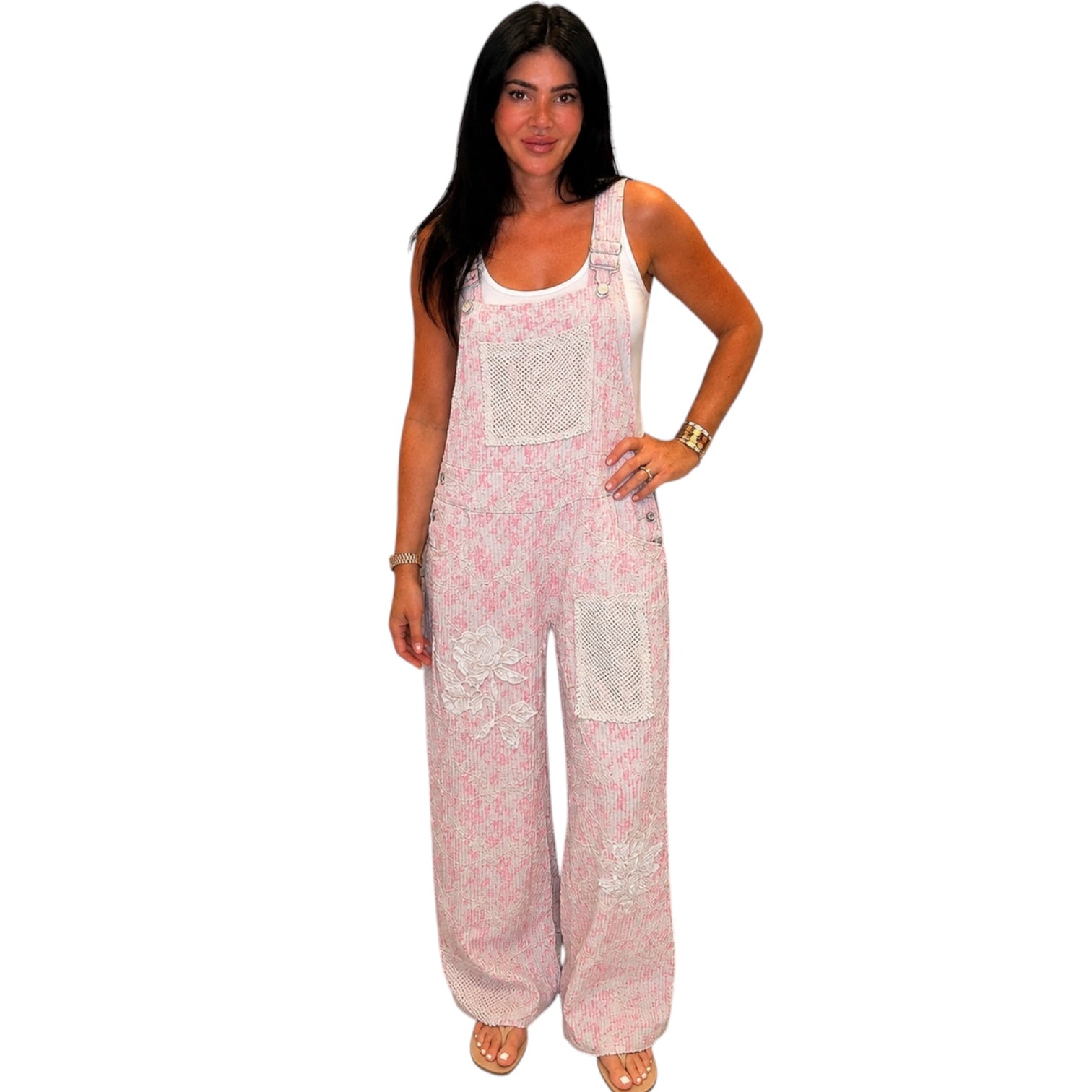 Woman wearing pink floral overalls on a white background