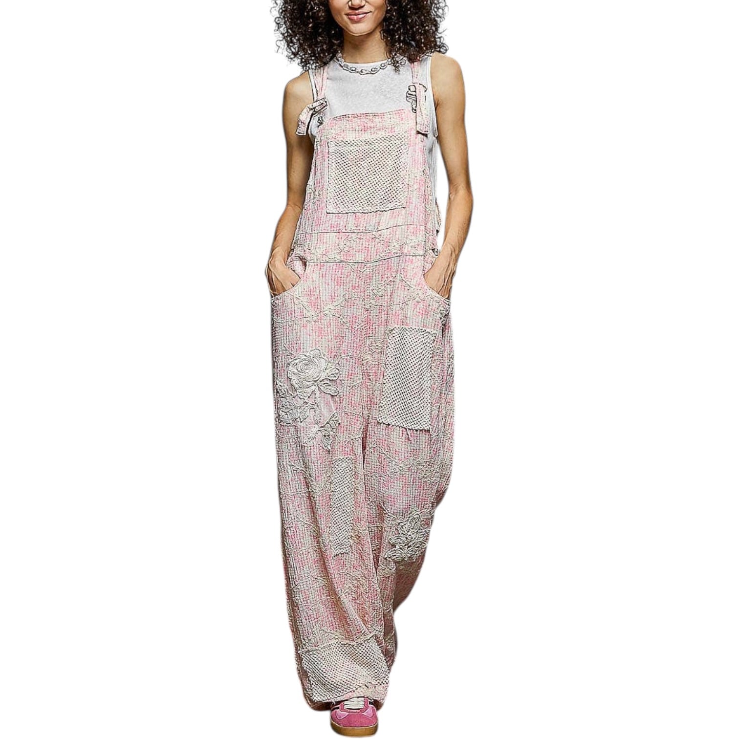 Woman wearing a floral overalls dress on a white background