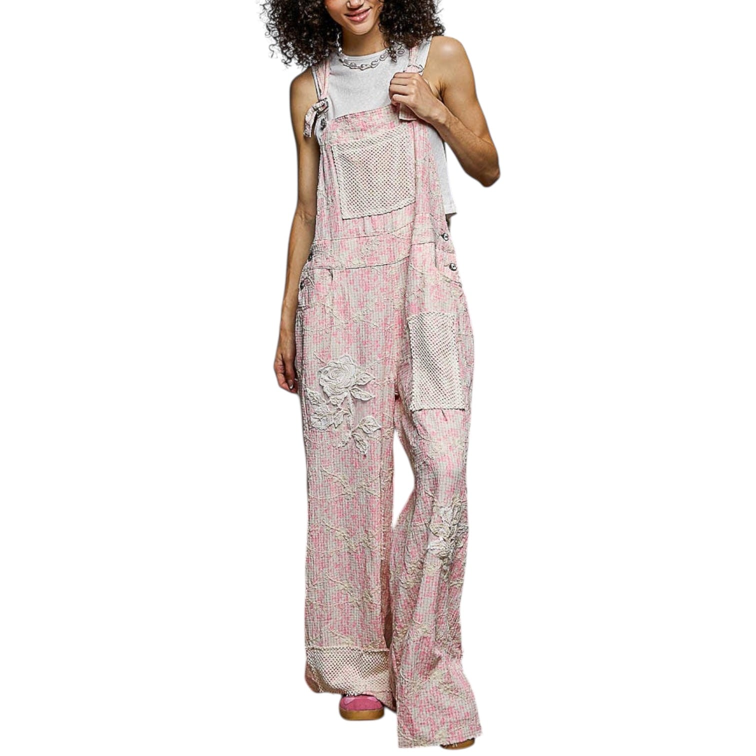 Woman wearing a pink floral jumpsuit on a white background