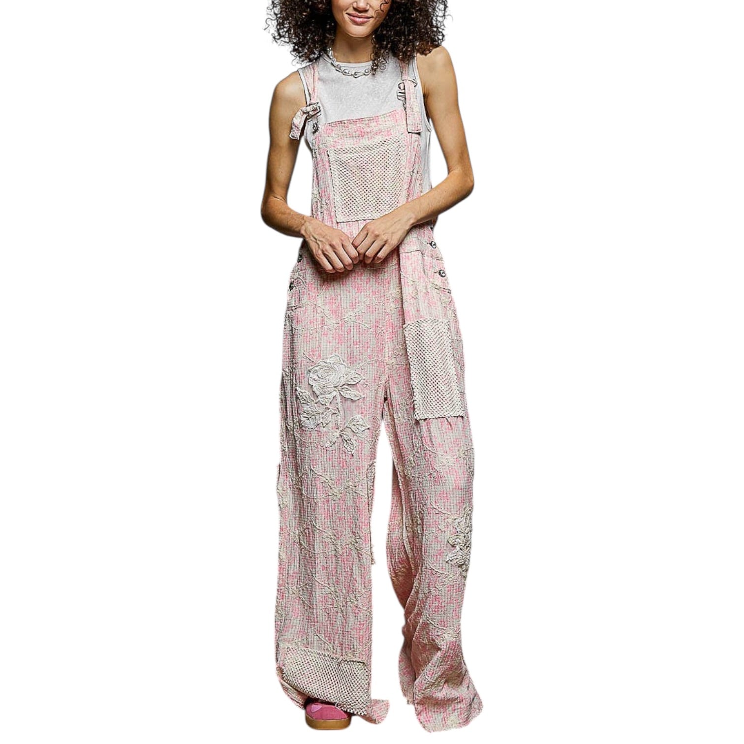 Person wearing a pink patterned overalls on a white background