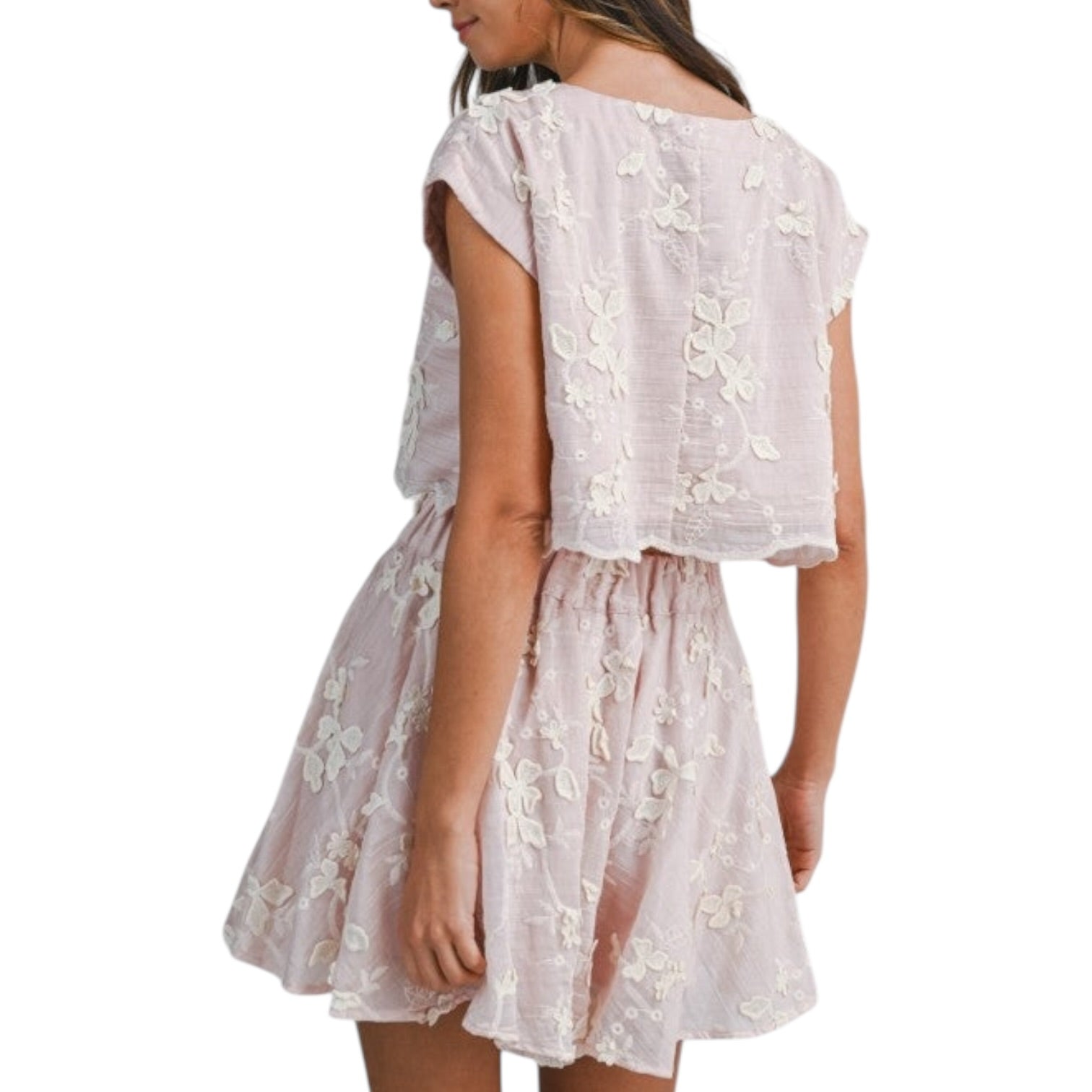 Pink lace set worn by a person on a white background