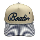 Beige cap with 'Boatin' embroidery and striped brim on a white background