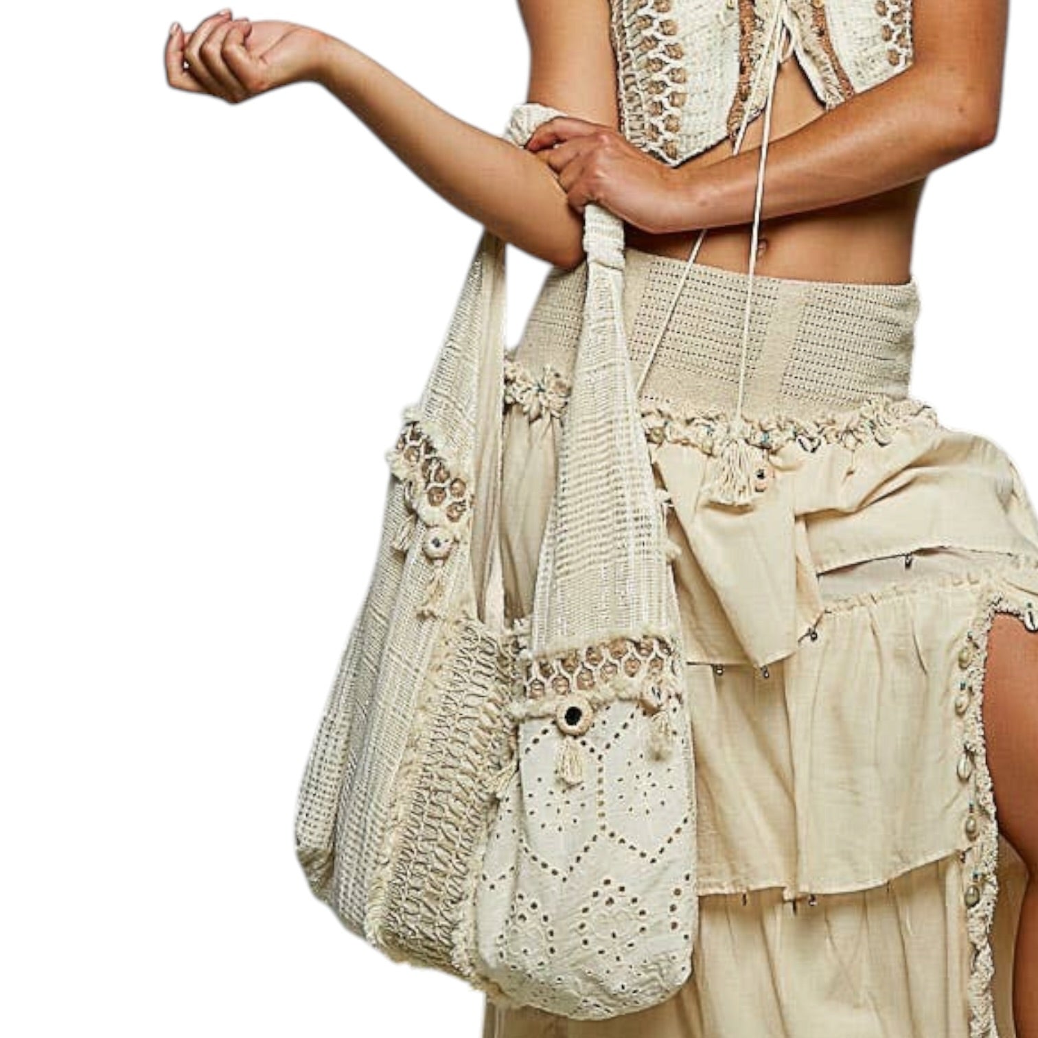 Person wearing a beige crochet outfit with a matching bag on a white background
