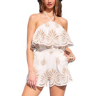 Woman wearing a white lace romper on a white background