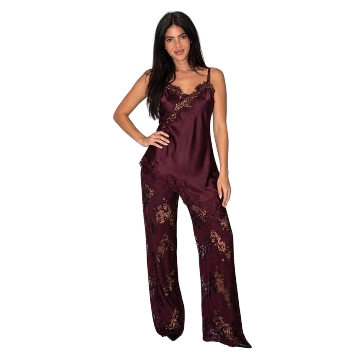 A woman modeling a two-piece satin pajama set in deep burgundy with gold floral lace patterns and ruffle trim, set against a plain white background.