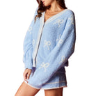 Light blue fleece cardigan with white patterns on a white background