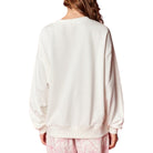 Person wearing a white sweatshirt with a plain background