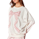 White sweatshirt with a pink bow design on a white background
