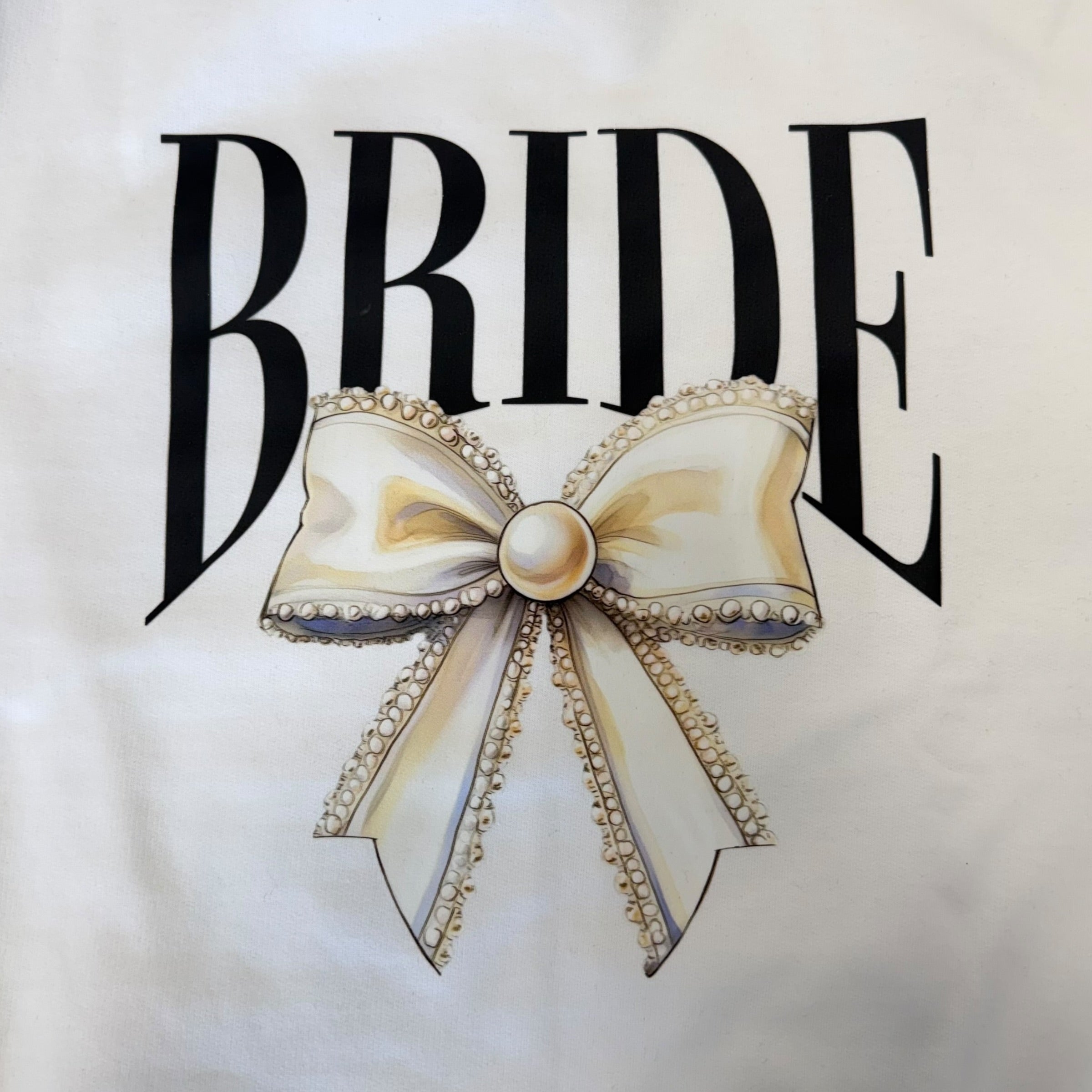 White sweatshirt with 'BRIDE' text and a decorative bow design.