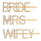 Three gold hair pins with 'BRIDE', 'MRS.', and 'WIFEY' text on a white background