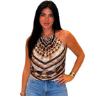 Woman wearing a patterned top and jeans on a white background