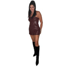 Woman wearing a burgundy short set and black knee-high boots on a white background