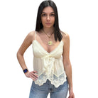 Woman wearing a lace-trimmed top and jeans on a white background