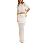Woman wearing a white crochet outfit on a white background