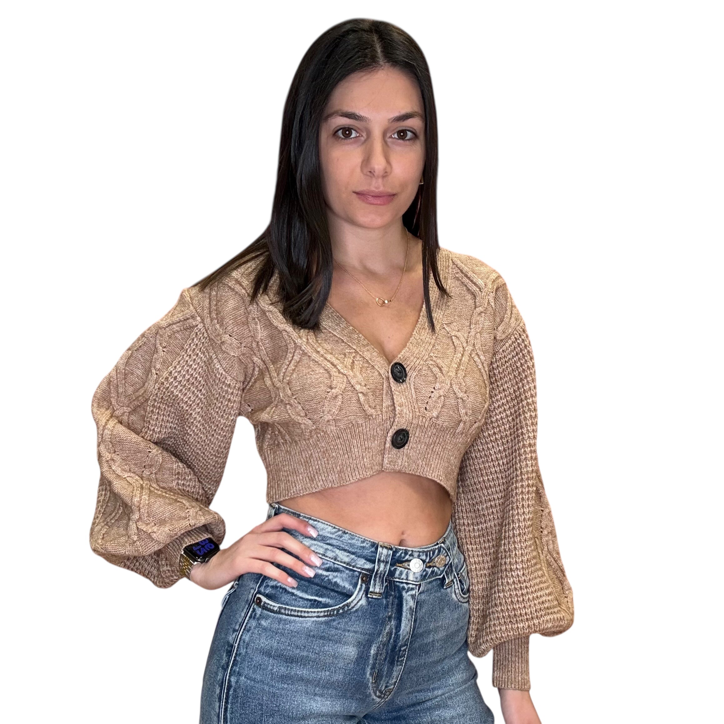 Woman wearing a beige knitted cardigan and blue jeans on a white background