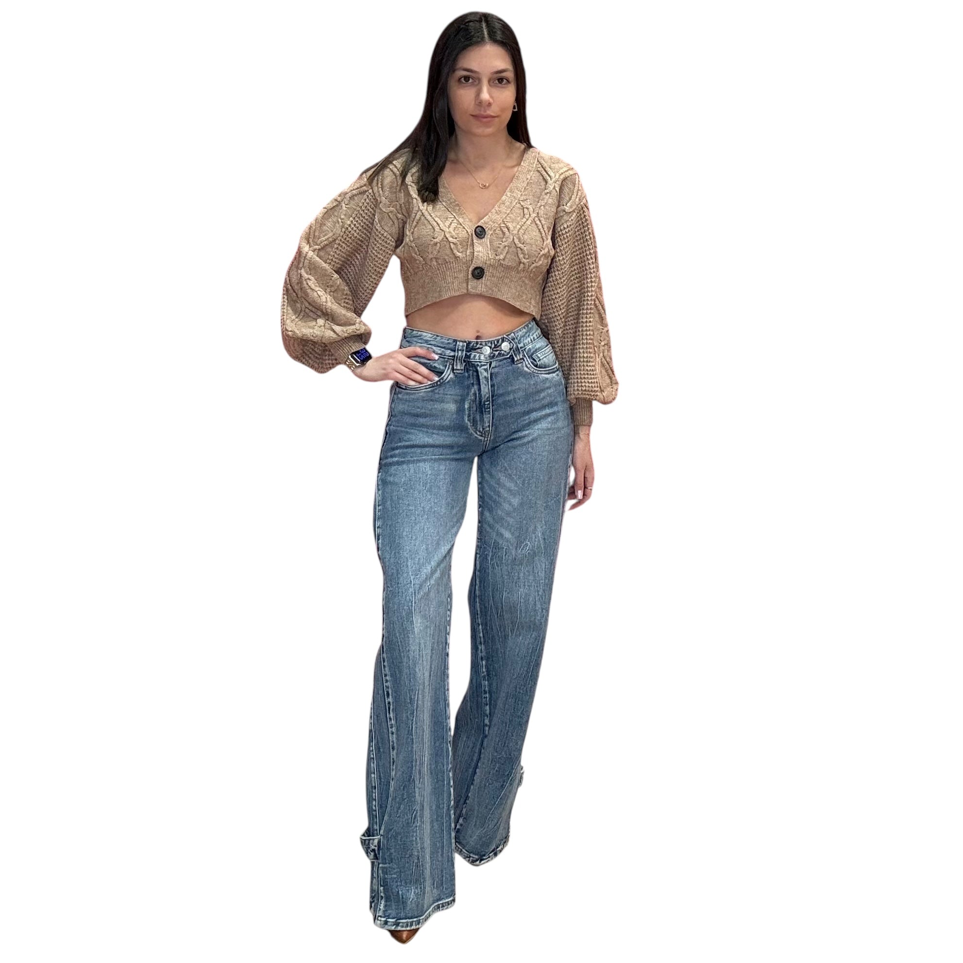 Woman wearing a beige cardigan and blue jeans on a white background