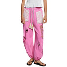 Pink distressed pants with lace details on a white background