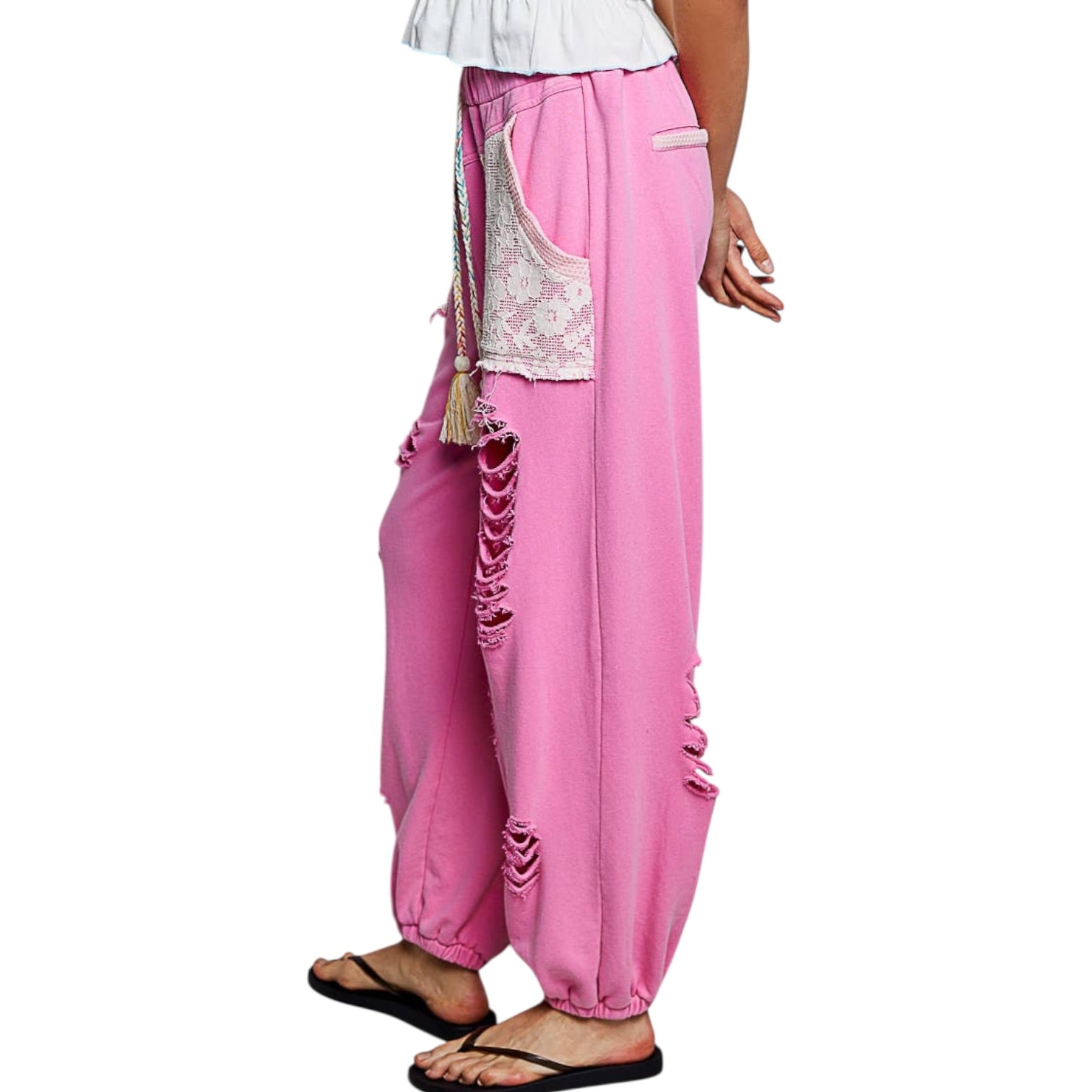 Pink baggy pants with lace detailing on a white background