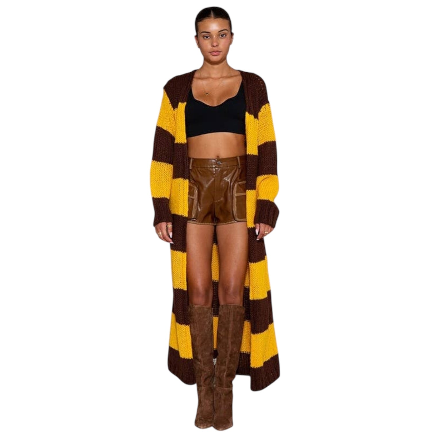 Woman wearing a long brown and yellow striped cardigan with a black top and brown leather shorts on a white background.